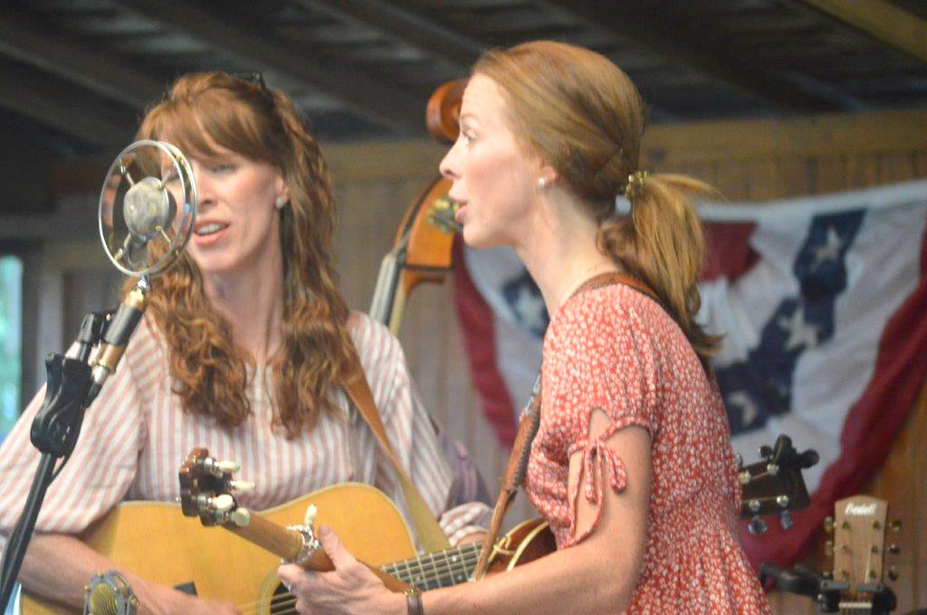 Twin sisters Penny Lea (left) and Katy Lou Clark make up the Purple Hulls. They entertained the Old Settlers crowd Friday night at the Jim Hogg City Park pavilion. The Purple Hulls sang a wide variety of bluegrass and gospel tunes to the delight of the crowd.